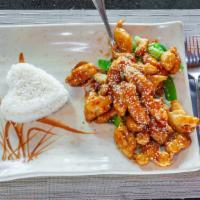 Sesame Chicken · Crispy chicken nuggets tossed in sweet and spicy sesame sauce. Served on bed of steamed vege...