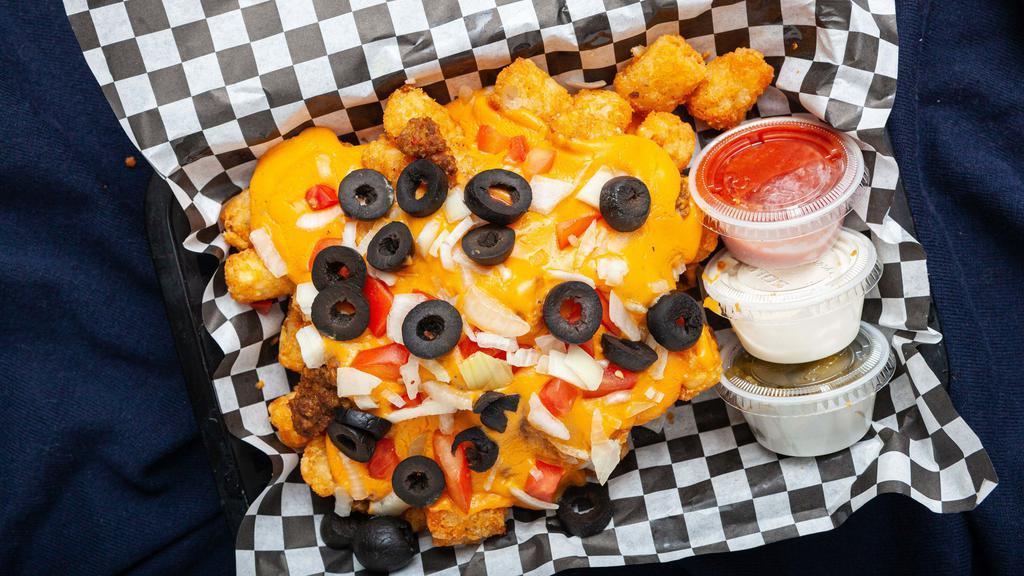 Loaded Totchos (Tatertot Nachos) · Tots covered in seasoned ground beef, Nacho cheese, olives, tomatoes, onions plus jalapenos, sour cream, and salsa on the side.