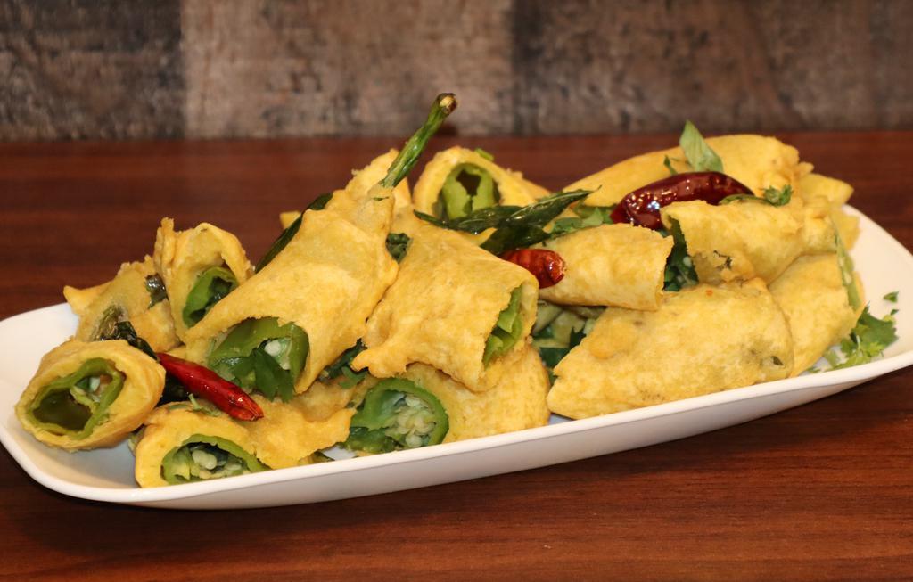 Cut Mirchi · Long green chilies, dipped in a chickpea and rice flour batter and double fried. An excellent and spicy choice for vegetarians.