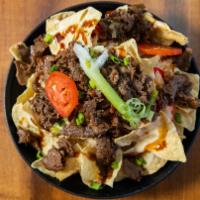 Korean Bbq Steak Nachos · Quick seared bulgogi beef, green and red chile queso Blanco, scallions and tomatoes served o...