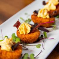 Deviled Eggs · Lightly battered eggs fried 'till crispy served with bacon candy on top.