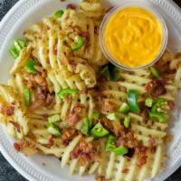 Loaded Cheese Fries · Platter of factory fries loaded with cheddar cheese sauce, smoked bacon, and jalapenos.