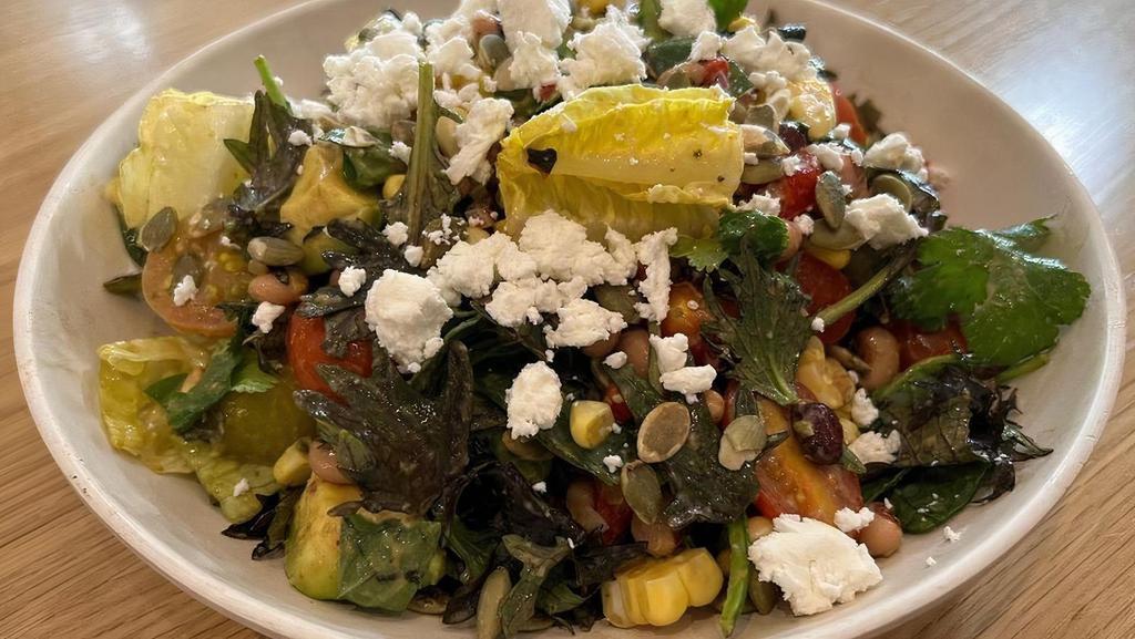 Southwest Kale Salad · Baby kale, romaine lettuce, black-eyed peas, roasted corn, and cherry. tomatoes, finished with fresh herbs, serrano peppers, crumbled goat. cheese, and fresh avocado, served with an avocado vinaigrette.