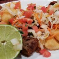 Yuca Con Chicharron · Fried cassava and fried pork topped with pickled cabbage.