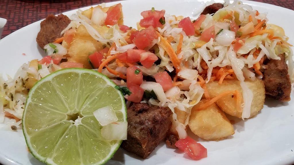 Yuca Con Chicharron · Fried cassava and fried pork topped with pickled cabbage.