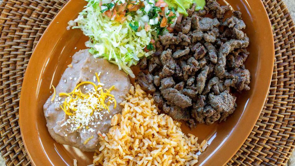 Carne Asada Plate · Carne asada with lettuce, guacamole and salsa Mexicana. Served with rice and refried beans. Three corn or one flour tortilla. No substitutions.
