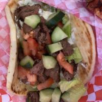 100% Leg Of Lamb Pita · Marinated lamb grilled over wood fire, topped with tzatziki sauce, lettuce, onion, tomato, c...