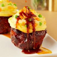 Signature Wagyu Meatloaf Cupcakes · Two Wagyu meatloaf cupcakes topped with a Sriracha glaze, whipped potato icing, peas and dic...
