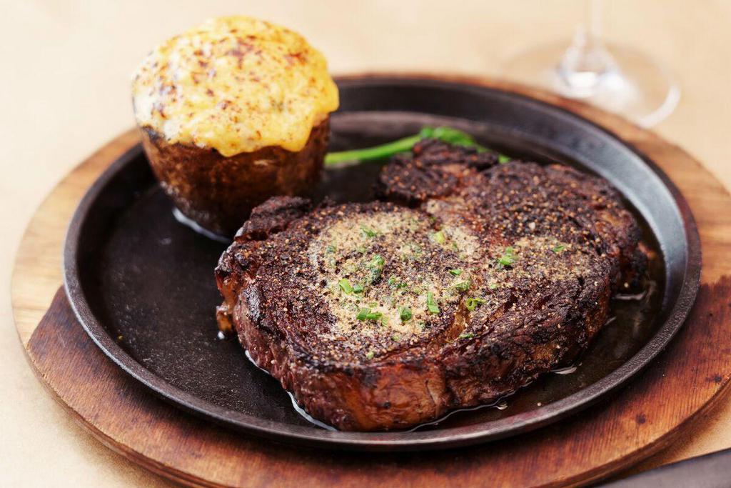 22 Oz. Bone-In Cowboy Ribeye* | Gf · 22 oz bone-in ribeye seasoned and broiled at 2000 degrees. Served with caramelized onions and topped with CARVE steak butter.