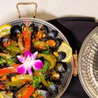 Mexilhões Na Cataplana · Mussels, tomatoes, and peppers in a white wine sauce.