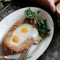 Egg In The Hole · Two fried eggs nestled in a housemade sesame Jerusalem bagel, served with chopped salad.. Co...