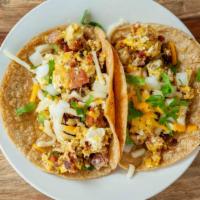 Breakfast Tacos · Tortillas stuffed with scrambled eggs, cheese and breakfast meat, topped with onions and cil...