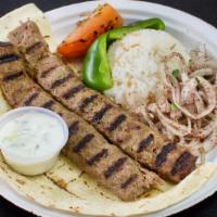 Adana Kebab · Long skewer of grilled chopped lamb served with spices, bread, rice, grilled tomato, peppers...