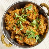 Rogan Josh · A traditional lamb curry covered with chopped onions, tomatoes, and freshly ground spices.