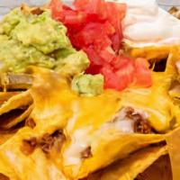 Super Nachos · Topped with your choice of shredded chicken or picadillo. Served with jalapeños, guacamole a...