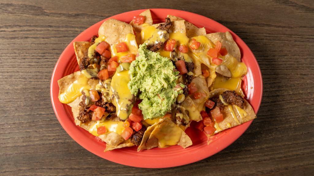 Sierra Nachos · Chips covered with queso, guacamole and tomato.