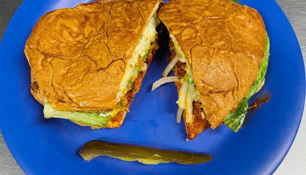 Torta/Pollo · Chicken marinated in mexican adobo sauce, All the Tortas come with french bread, lettuce, avocado, tomatoes, grilled and raw onions, mayonnaise, mustard, cheese, chilies in vinagre.
