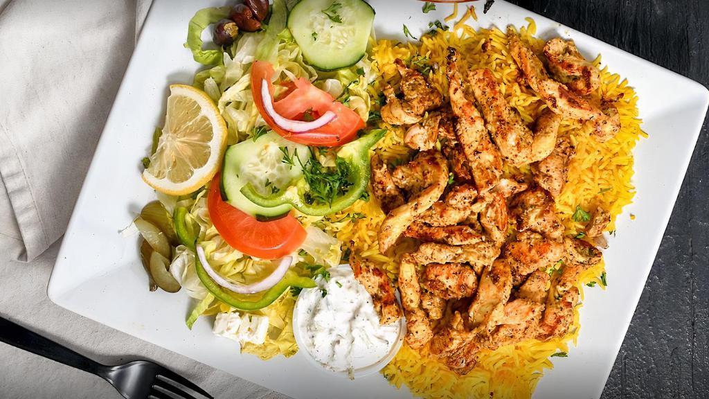 Chicken Kebab Rice Bowl · Grilled chicken over basmati rice with hummus, diced cucumber and tomato salad, shredded green cabbage and a drizzle of tahini sauce.