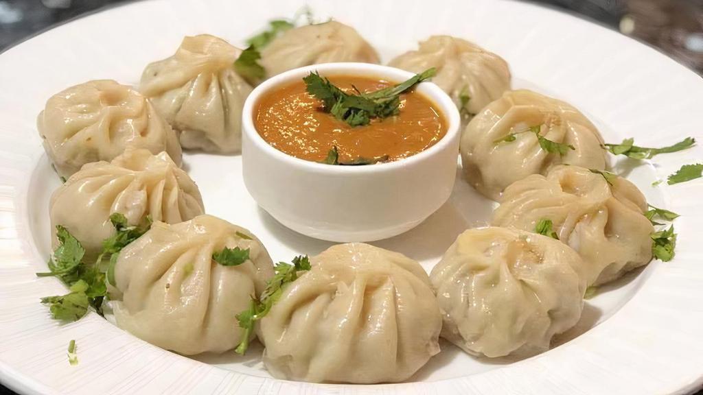  Chicken Steamed Momo 10 Pcs (Dumplings) · Chicken Momo - Ten pieces steamed Momo (Dumplings ) made from scratch with handmade dough, minced chicken, vegetables, onion, garlic, ginger, Himalaya spices and serve with freshly made Momo sauce and hot chilly sauce on a side.