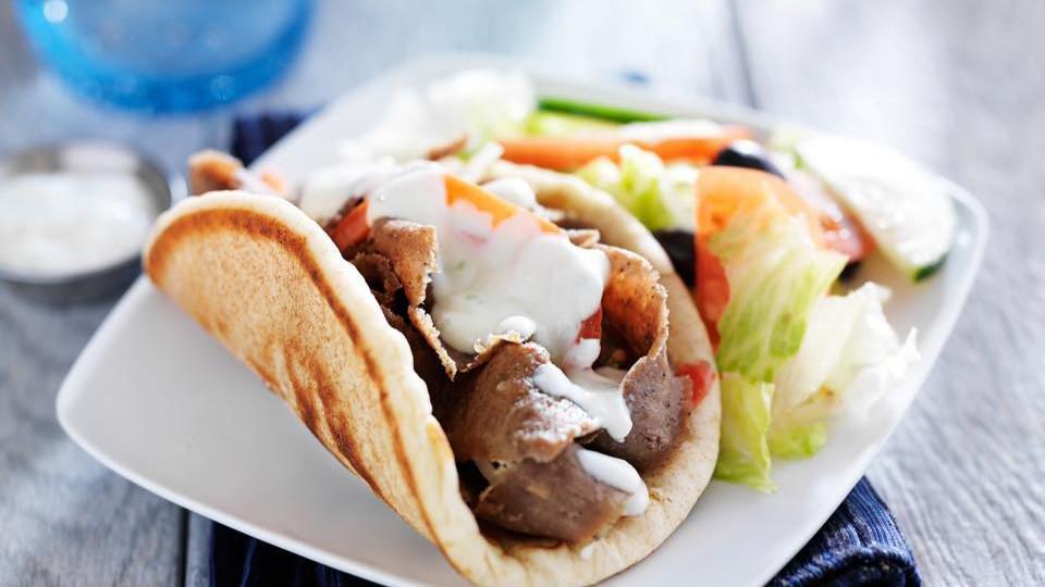 Authentic Pork Gyro · Fresh marinated and seasoned pork wrapped in pita with tomatoes, onions, tzatziki (cucumber yogurt sauce) and topped with fries, just as you would eat in Greece.