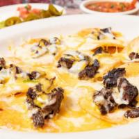 Steak Nachos · Crispy corn chips covered with steak, refried beans and cheese. Served with guacamole, jalap...