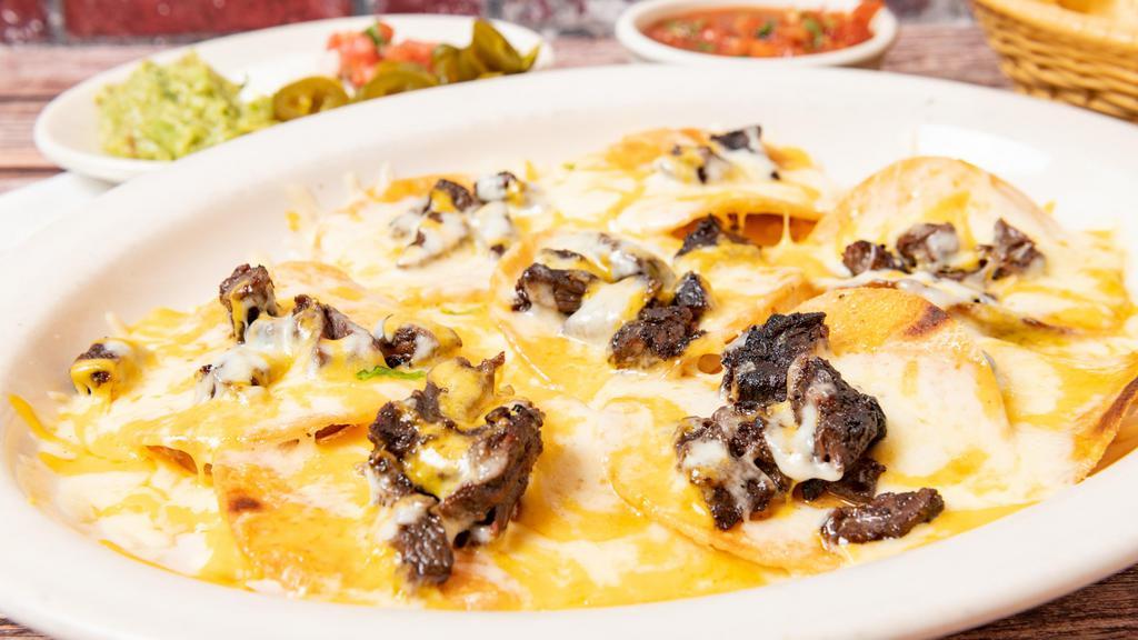 Steak Nachos · Crispy corn chips covered with steak, refried beans and cheese. Served with guacamole, jalapenos, sour cream, and pico de gallo on the side.