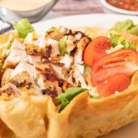 Tostada Chicken Salad · Crispy flour tortilla shell filled with romaine lettuce, tomatoes, shredded cheese, guacamol...