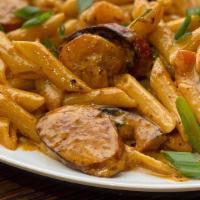 Cajun Shrimp Pasta · Shrimp and turkey sausage in a Cajun cream sauce with tomatoes, scallions and topped with ch...