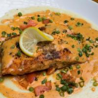 Blackened Salmon & Grits · Fresh blackened salmon served over cheesy grits with our signature cajun cream sauce and tom...