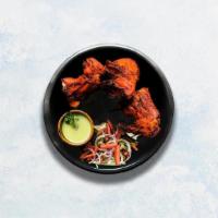 Tandoori Chicken · Chicken marinated in yogurt and herbs roasted in a traditional Indian clay oven.