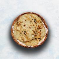 Butter Naan · Indian white flour flatbread baked to perfection in a traditional Indian clay oven and glaze...