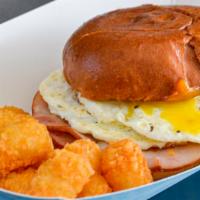 Breakfast Sandwich · Fried egg, American cheese and choice of ham or bacon served on an oil top bun and tater tot...