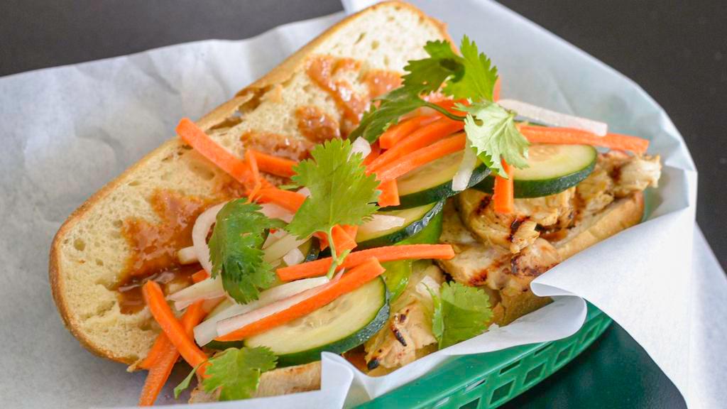 Chicken Banh Mi · Marinated chicken breast, house-made sauce, pickled carrots and daikon, sliced cucumber and cilantro and a baguette.