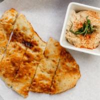 Hummus · Lemon and roasted garlic hummus served with flatbread.