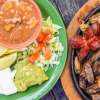 La Mexicana · Beef and chicken fajitas, grilled shrimp and sausage on a cast iron skillet with pico de gal...