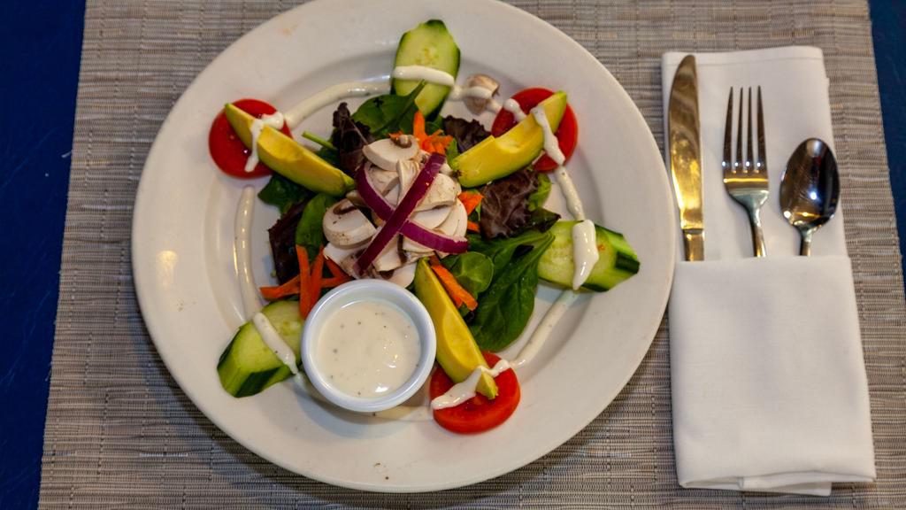 Ensalada De La Casa · Field greens salad with avocado, cucumber, tomatoes, mushrooms and carrots tossed with our house vinaigrette.