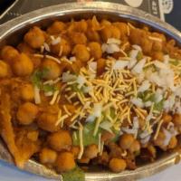 Samosa Chaat · Samosa topped with chickpeas, tomatoes, and spices. Served with sweet yogurt, tamarind and m...