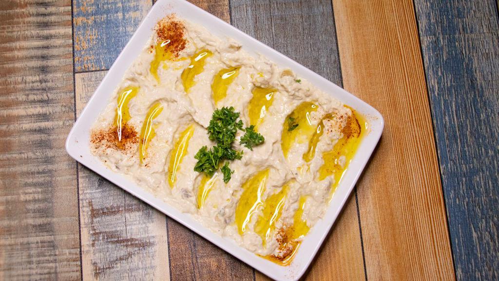 Hummus · Chickpeas blended with tahini, lemon juice, garlic and drizzled with olive oil.