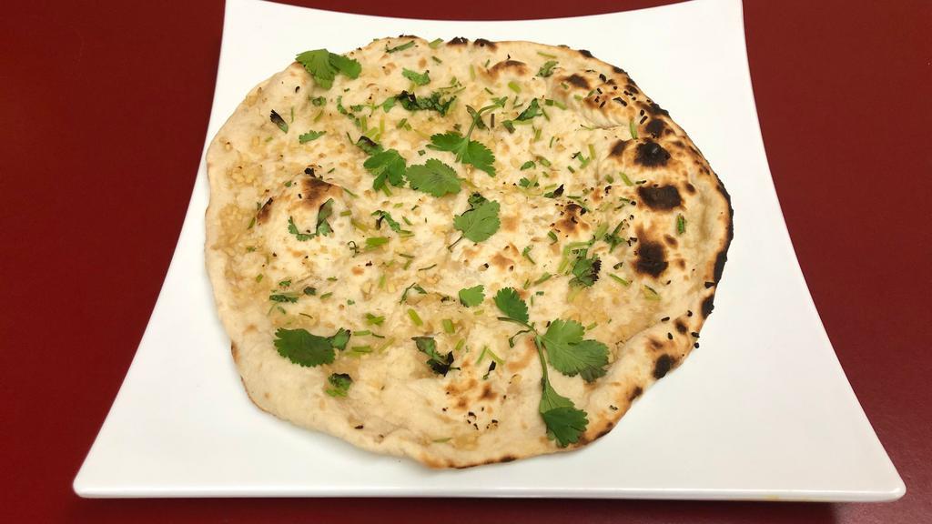 Garlic Naan · Traditional leavened white flour bread freshly cooked in a tandoor oven topped with garlic & cilantro.