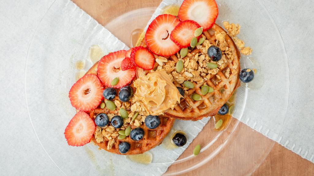 Protein Waffle · Protein infused waffle sliders, topped with brown rice syrup, strawberries, blueberries, hemp granola, PB2 powder, pumpkin seeds, and a scoop of açaí blend.