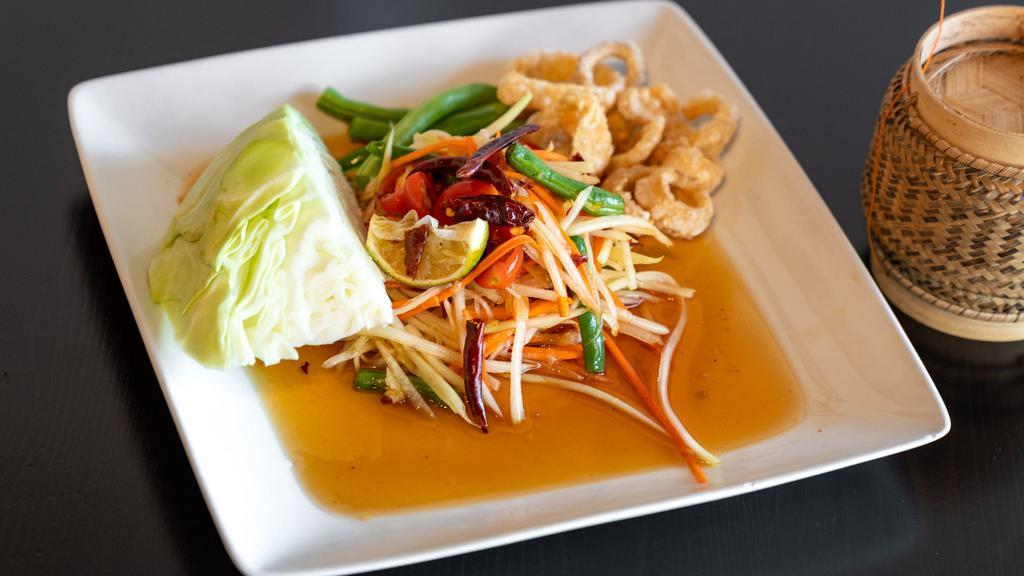Papaya Salad (Som Tam) · Shredded green papaya, Thai chili, garlic, cherry tomatoes, carrot, green beans, and peanuts, tossed with Lime juice mixed chili sauce. Laos style will add Thai eggplant, salted crab, and homemade fish paste.