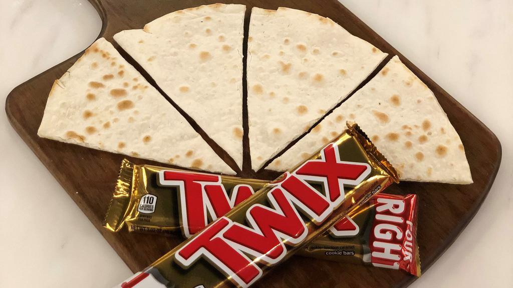 Twix Sajj · Authentic Lebanese thin bread (sajj) filled with Twix chocolate and baked on a convex metal griddle.