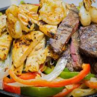 Combo Fajita · Marinated sizzling strips of steak, chicken and shrimp,
topped with sauteed onions and green...