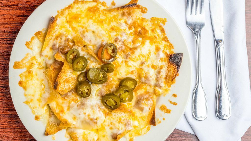 Nachos · Tortilla chips covered with refried beans, melted cheese and jalapeño pepper strips.