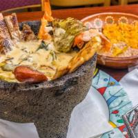 El Molcajete Special · Inside the volcanic hot stone comes with a bed of a creamy sauce with onions and chile pobla...