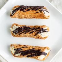 Cannoli · Cinnamon spiked pastry shell filled with sweet ricotta cream with chocolate chips.