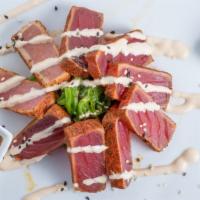 Seared Ahi Tuna Sashimi · sliced & served w seaweed salad, wasabi, ginger, piri piri cream & chili-soy dipping sauce.