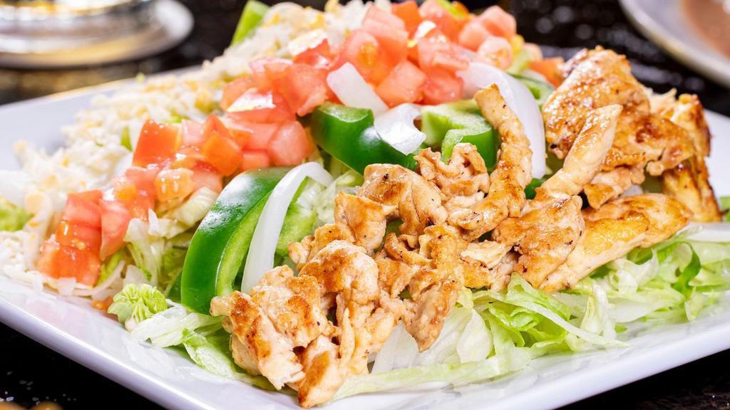 El Colonial Salad · Strips of grilled chicken served with lettuce, tomatoes, onions, green peppers, shredded cheese, and guacamole.