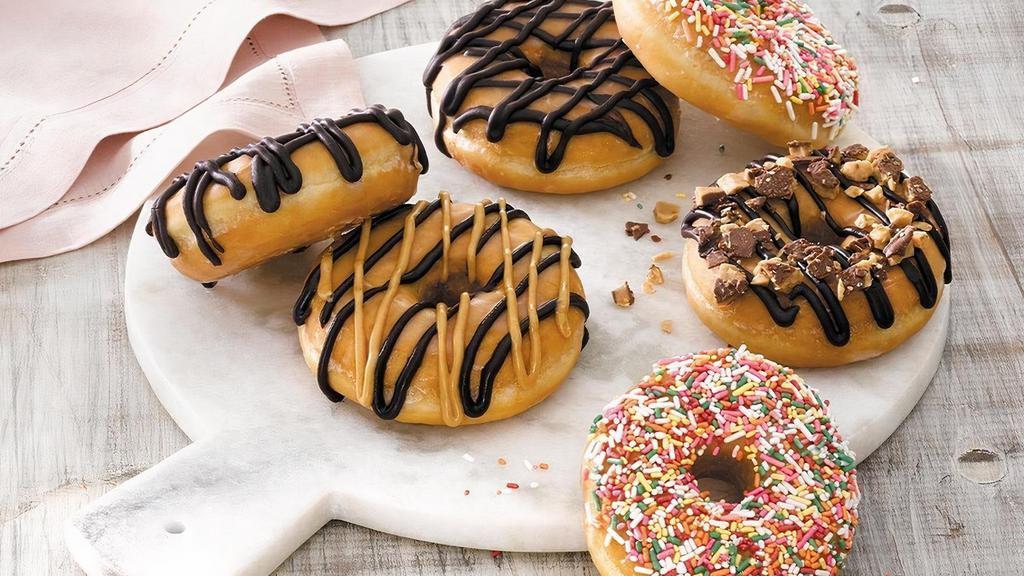 Heath® Crunch Doughnut · Heath® toffee pieces and chocolate icing atop a classic glazed doughnut