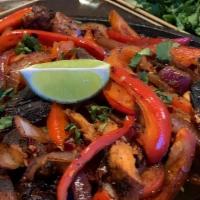 Chicken And Shrimp Fajitas · Ancho grilled chicken and Cajun grilled shrimp  served with a sautéed red onions and red bel...